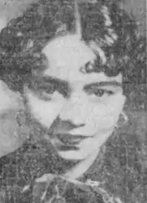 A smiling young African-American woman with dark glossy hair parted and curled