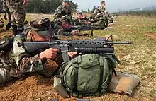 A U.S. Marine takes aim with an M16A2 fitted with the M203 40 mm grenade launcher