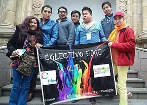 Carlos Parra holds up a banner alongside other LGBT organizers.