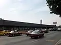 Picture of the station in the middle of Río Consolado Avenue. Several automobiles surround the station.