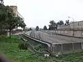 Picture of a track going from the underground to the overground level. In the background, the Mexico City International Airport is seen