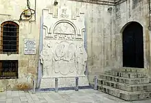 Light gray bas-relief on church wall, with one representative of each side facing each other