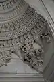Detail of Baroque carvings above the lateral courtyard entrance, replacing the traditional muqarnas