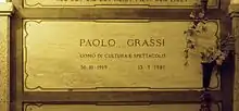 A marble gravestone on the wall of a crypt