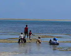 Group of Kenyan people seabathing at low tide at Nyali Beach.