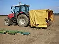 Five-row transplanter being towed by a Massey Ferguson 6265 tractor.
