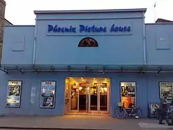 Plain façade, painted pale blue, with an awning