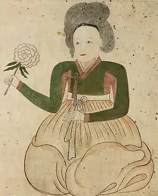 Lady on white background holding flower.