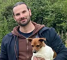 Informal photograph of Plunkett holding a dog