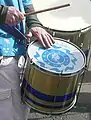 Repinique being played with a stick and a hand
