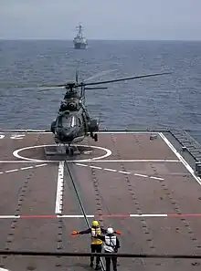 A RSN Super Puma taking off from RSS Resolution with USS Russell in the background on 7 June 2004.