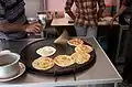 Roti canai is cooked on a tava with a lot of oil.