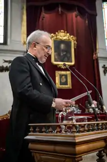 Machado at a lectern