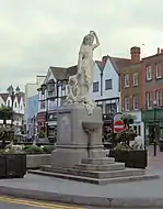 Statue on a plinth of a woman in classical dress carrying a jug on her shoulder and holding a child's hand. Steps upto the base of the plinth lead to a drinking fountain.