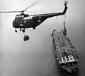 An HMR-163 HUS-2 over USS Sicily (CVE-118), 1952.