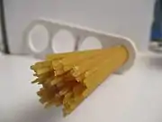 Dried spaghetti measured with a "spaghetti measure". One portion of dried pasta weighs .mw-parser-output .frac{white-space:nowrap}.mw-parser-output .frac .num,.mw-parser-output .frac .den{font-size:80%;line-height:0;vertical-align:super}.mw-parser-output .frac .den{vertical-align:sub}.mw-parser-output .sr-only{border:0;clip:rect(0,0,0,0);clip-path:polygon(0px 0px,0px 0px,0px 0px);height:1px;margin:-1px;overflow:hidden;padding:0;position:absolute;width:1px}116&nbsp;g (4+1⁄8&nbsp;oz), twice the amount of one serving on the package (12&nbsp;mm circle or 60&nbsp;g.). The measure can portion out 1, 2, 3, or 4 servings based on the diameter of the circle.
