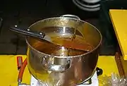 A pot of steaming hot syrup is used to fill the stroopwafels