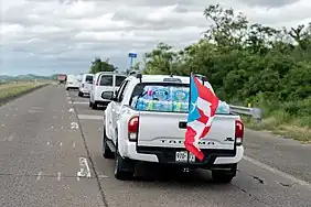 A Toyota Tacoma pick-up truck on PR-52, with water and flag, after Hurricane Maria (2017)