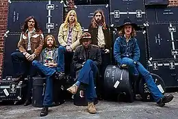 The musicians standing in a line, facing the camera