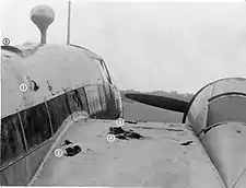 a black and white photograph of a portion of the fuselage and wing of an aircraft with holes that served as foot and hand holds