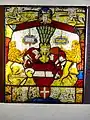 The Austrian Bindenschild, gules a fess argent, originally the Babenberg coat of arms. Below the Bindenschild is a small coat of arms of the city of Vienna, gules a cross argent