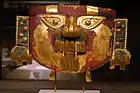 Sican headdress mask; 10th-11th century; gold, silver & paint; height: 29.2&nbsp;cm (11.mw-parser-output .frac{white-space:nowrap}.mw-parser-output .frac .num,.mw-parser-output .frac .den{font-size:80%;line-height:0;vertical-align:super}.mw-parser-output .frac .den{vertical-align:sub}.mw-parser-output .sr-only{border:0;clip:rect(0,0,0,0);clip-path:polygon(0px 0px,0px 0px,0px 0px);height:1px;margin:-1px;overflow:hidden;padding:0;position:absolute;width:1px}1⁄2 in.); Metropolitan Museum of Art