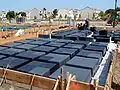 Wafflemat foundations like this one have covered over 25,000,000 sq ft (2.3 km2) of ground. They are built using void forms that allow the foundation to compensate for collapsible soils.