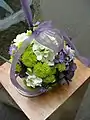 A pomander bouquet, shaped completely round and worn by a ribbon on the wrist.
