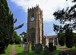 A church tower with churchyard and headstones in the foreground