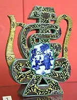 Wine pot in the shape of Shou character. Qing Dynasty, Kangxi reign period, 1680-1720 CE. Porcelain painted in underglaze cobalt blue and overglaze colored enamels. From Jingdezhen, China