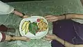 Women celebrating their divinity by gifting  Kosambri with turmeric, kumkum, betel leaves, betel nut and bananas.