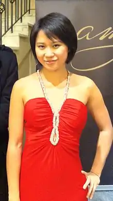 Yuja Wang in a shoulder-free red dress, looking at the camera