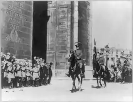 General John Pershing rides under Arc de Triomphe in parade with aide-de-camp George C. Marshall. 1919.