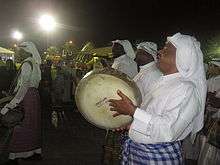 Men in white robes with instruments